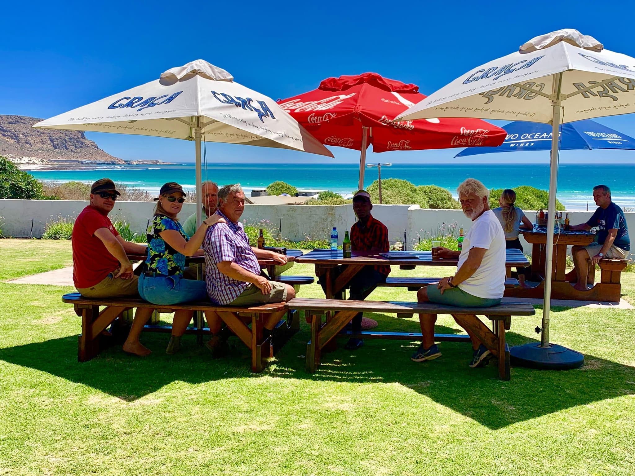 Group enjoying meal with turquoise beach ocean view