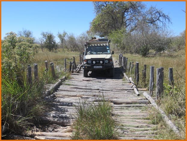 4x4 Land Cruiser überquert eine rustikale Holzbrücke in Botswana