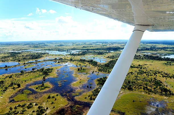 Luftaufnahme aus dem Flugzeug über die Wasserwege und grünen Inseln des Okavango-Deltas