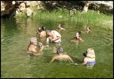 Groep baadt in natuurlijke warmwaterbron met weelderige vegetatie