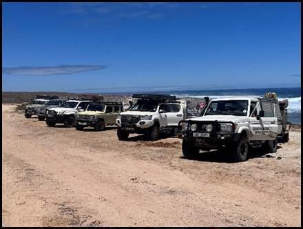 Fleet of 4x4 vehicles lined up on the coastal sand near Sout River