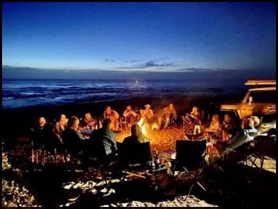 Guests gathered around campfire for the legendary seafood feast at Muisbosskerm