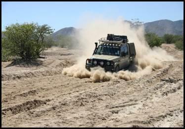 4x4-voertuig wervelt stof op op een off-road woestijnpad