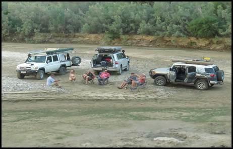 4x4-konvooi ontspant bij de rivier met groepsleden